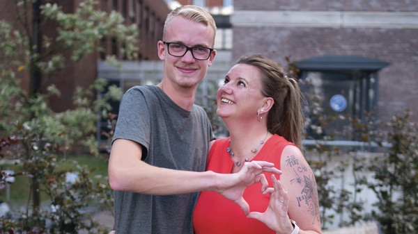 Mutter und Sohn stehen Arm in Arm und formen mit den Händen ein Herz, Titelgeschichte Magazin Herzlich, Immanuel Albertinen Diakonie Mutter und Sohn stehen Arm in Arm und formen mit den Händen ein Herz, Titelgeschichte Magazin Herzlich, Immanuel Albertinen Diakonie