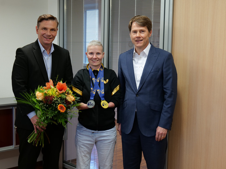 Stephanie Grebe zeigt ihre Gold- und Silbermedaille der Para-Tischtennis-Europameisterschaft und wird von Andreas Mende und Dr. Thorsten Minuth herzlich in der Immanuel Albertinen Diakonie beglückwünscht. Stephanie Grebe zeigt ihre Gold- und Silbermedaille der Para-Tischtennis-Europameisterschaft und wird von Andreas Mende und Dr. Thorsten Minuth herzlich in der Immanuel Albertinen Diakonie beglückwünscht.