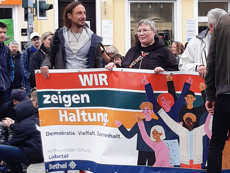Teilnehmende des Protestmarsches halten ein Banner mit der Aufschrift Wir zeigen Haltung Teilnehmende des Protestmarsches halten ein Banner mit der Aufschrift Wir zeigen Haltung
