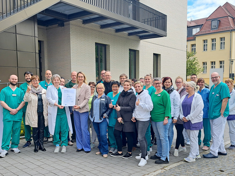 Mitarbeitende des Immanuel Klinikums Bernau vor dem Klinikgebäude mit dem Zertifikat Qualitätszertifikat DIN EN ISO 9001:2015 Mitarbeitende des Immanuel Klinikums Bernau vor dem Klinikgebäude mit dem Zertifikat Qualitätszertifikat DIN EN ISO 9001:2015
