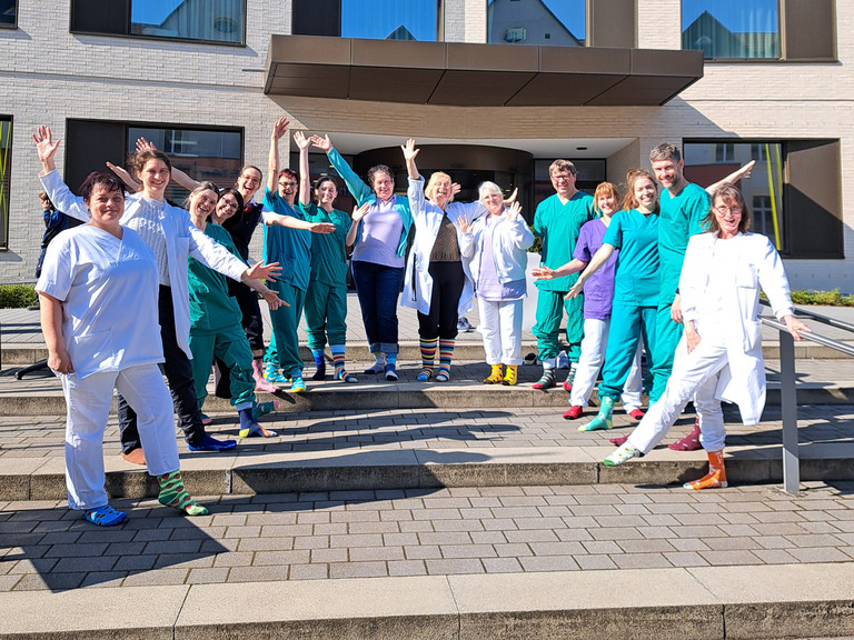 Mitarbeitende des Immanuel Klinikum Bernau stehen vor dem Eingang und zeigen ihre bunten Socken anlässlich des Welt-Down-Syndrom Tages Mitarbeitende des Immanuel Klinikum Bernau stehen vor dem Eingang und zeigen ihre bunten Socken anlässlich des Welt-Down-Syndrom Tages