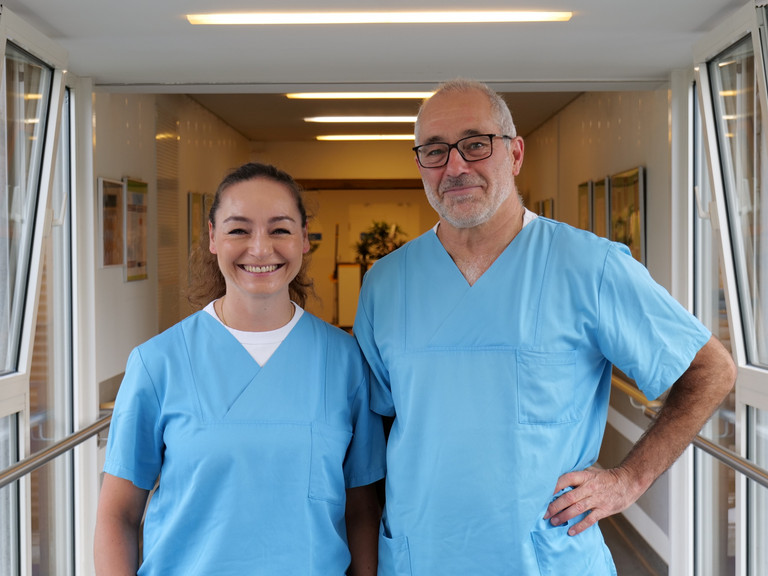 Dr. Anissa Habib-El-Chafchak und Dr. Matthias Gasthaus aus der Klinik für Innere Medizin – Kardiologie im Albertinen Herz- und Gefäßzentrum am Standort Evangelisches Amalie Sieveking Krankenhaus in Hamburg blicken in blauer Funktionskleidung in die Kamera. Dr. Anissa Habib-El-Chafchak und Dr. Matthias Gasthaus aus der Klinik für Innere Medizin – Kardiologie im Albertinen Herz- und Gefäßzentrum am Standort Evangelisches Amalie Sieveking Krankenhaus in Hamburg blicken in blauer Funktionskleidung in die Kamera.