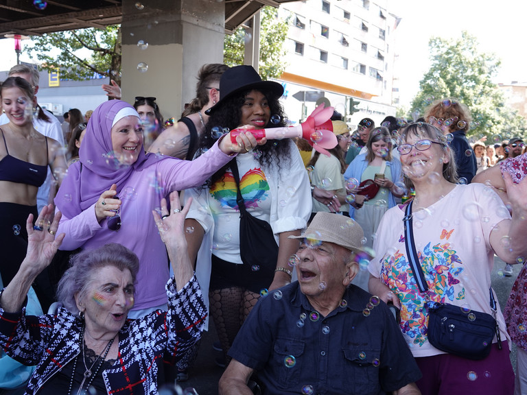 Eine Gruppe fröhlicher Menschen unterschiedlichen Alters mit einer Seifenblasenmaschine beim Besuch des Christopher Street Days in Berlin 2026 vom Immanuel Seniorenzentrum Schöneberg. Eine Gruppe fröhlicher Menschen unterschiedlichen Alters mit einer Seifenblasenmaschine beim Besuch des Christopher Street Days in Berlin 2026 vom Immanuel Seniorenzentrum Schöneberg.