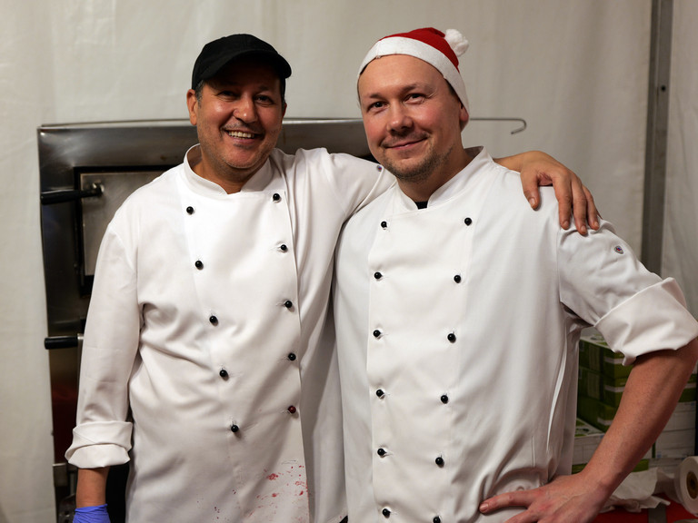 Zwei Köche der Albertinen Services Hamburg in weißen Kochschürzen blicken fröhlich in die Kamera bei der Weihnachtsfeier 2025 von Amalie Sieveking Krankenhaus, Residenz am Wiesenkamp, Feierabendhaus Volksdorf und Albertinen Kindertagesstätte Volksdorf auf dem Gesundheitscampus Volksdorf in Hamburg Zwei Köche der Albertinen Services Hamburg in weißen Kochschürzen blicken fröhlich in die Kamera bei der Weihnachtsfeier 2025 von Amalie Sieveking Krankenhaus, Residenz am Wiesenkamp, Feierabendhaus Volksdorf und Albertinen Kindertagesstätte Volksdorf auf dem Gesundheitscampus Volksdorf in Hamburg