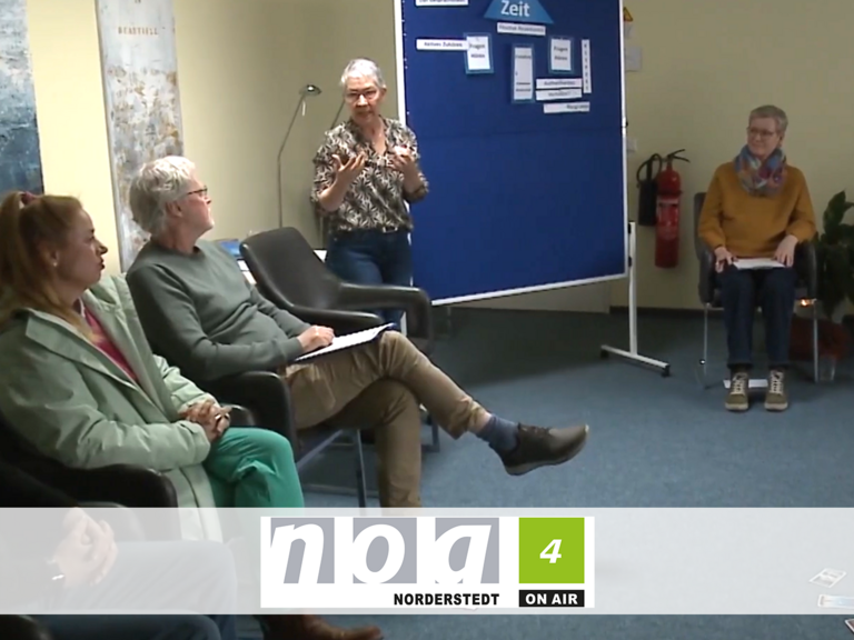 Kursleiterin Sabine Bornhöft steht an einer Pinnwand und spricht mit den im Kreis sitzenden Teilnehmenden beim Kurs für den ehrenamtlichen mobilen Hospizdienst im Albertinen Hospiz Norderstedt. Kursleiterin Sabine Bornhöft steht an einer Pinnwand und spricht mit den im Kreis sitzenden Teilnehmenden beim Kurs für den ehrenamtlichen mobilen Hospizdienst im Albertinen Hospiz Norderstedt.